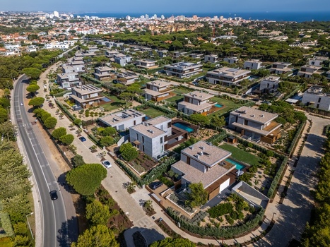 Aerial view of Quinta da Marinha featuring modern villas with swimming pools surrounded by lush pine trees and landscaped gardens in Cascais Lisbon Portugal. Aerial view of Quinta da Marinha featuring modern villas with swimming pools surrounded by lush pine trees and landscaped gardens in Cascais Lisbon Portugal.