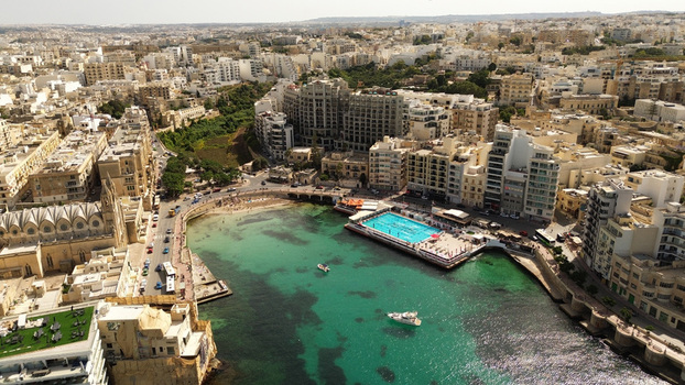 Aerial view of Balluta Bay with the Carmelite Parish Church a swimming pool and surrounding urban architecture in Malta. Aerial view of Balluta Bay with the Carmelite Parish Church a swimming pool and surrounding urban architecture in Malta.