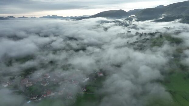 Aerial view of misty mountains and serene valley Infiesto Asturias Spain.