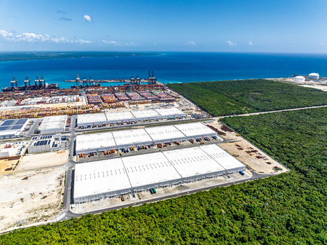 Aerial view of DP World Dominicana port facility featuring large warehouses shipping containers and cranes along the coastline in Boca Chica Santo Domingo Dominican Republic. Aerial view of DP World Dominicana port facility featuring large warehouses shipping containers and cranes along the coastline in Boca Chica Santo Domingo Dominican Republic.