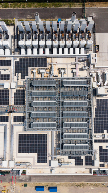 Aerial view of a large industrial facility featuring extensive solar panel arrays cooling systems and complex infrastructure in Milan Lombardy Italy.