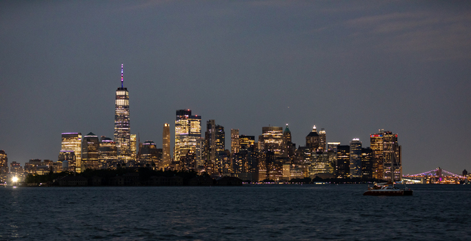 New York New York United States 08 July 2021 View of the illuminated Manhattan skyline at night featuring One World Trade Center and skyscrapers reflecting over the harbor. New York New York United States 08 July 2021 View of the illuminated Manhattan skyline at night featuring One World Trade Center and skyscrapers reflecting over the harbor.