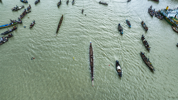 Baghabari Bangladesh 20 August 2022 Aerial view of traditional long boats racing on the river with many spectators in smaller boats.