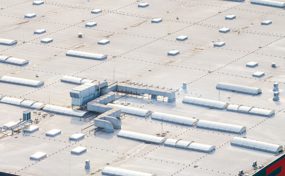 Aerial view of a large industrial building roof featuring numerous skylights ventilation ducts and HVAC units in Kowale Pomeranian Voivodeshi Poland. Aerial view of a large industrial building roof featuring numerous skylights ventilation ducts and HVAC units in Kowale Pomeranian Voivodeshi Poland.