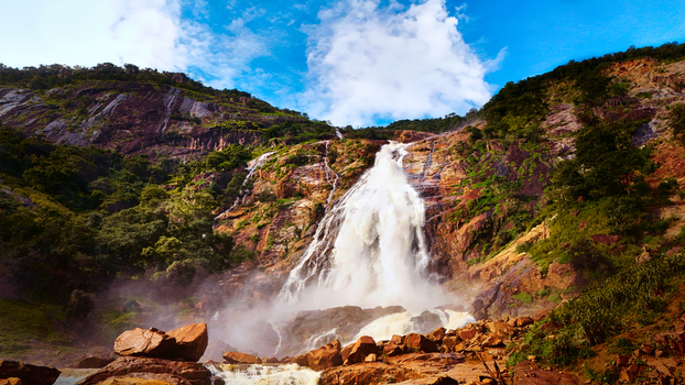 Aerial view of a majestic waterfall cascading down rocky cliffs mist rising in the air under a blue sky Farin Ruwa Waterfalls Nasarawa Nigeria. Aerial view of a majestic waterfall cascading down rocky cliffs mist rising in the air under a blue sky Farin Ruwa Waterfalls Nasarawa Nigeria.