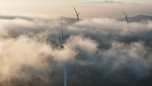 Aerial view of Windpark Freilanderalm turbines and clouds Austria.