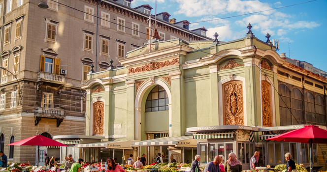 Rijeka Croatia 19 September 2026 View of the historic Rijeka Central Market with its ornate green facade bustling stalls red umbrellas and people shopping on a sunny day. Rijeka Croatia 19 September 2026 View of the historic Rijeka Central Market with its ornate green facade bustling stalls red umbrellas and people shopping on a sunny day.