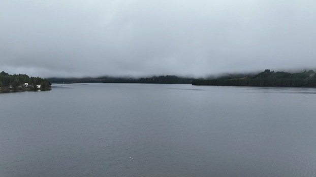 Aerial view of Corani Lake surrounded by dense forests and rolling hills under a heavy overcast sky in Chapare Cochabamba Department Bolivia. Aerial view of Corani Lake surrounded by dense forests and rolling hills under a heavy overcast sky in Chapare Cochabamba Department Bolivia.