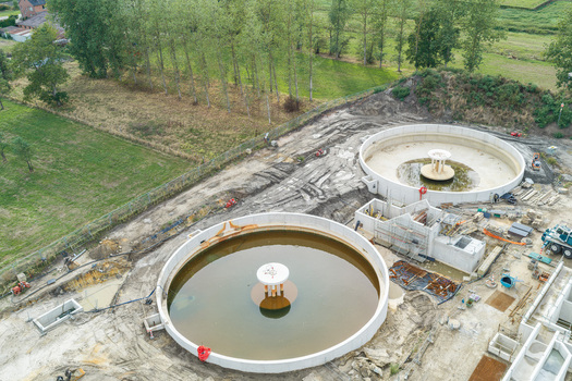 Diepenbeek Belgium 30 August 2026 Aerial view of a wastewater treatment plant featuring large circular concrete tanks under construction surrounded by green fields and trees. Diepenbeek Belgium 30 August 2026 Aerial view of a wastewater treatment plant featuring large circular concrete tanks under construction surrounded by green fields and trees.