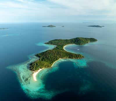 Aerial view of Malcapuya Island with lush green vegetation white sand beach and turquoise coral reef waters in the sea Coron Mimaropa Philippines. Aerial view of Malcapuya Island with lush green vegetation white sand beach and turquoise coral reef waters in the sea Coron Mimaropa Philippines.