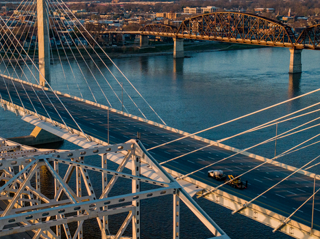 Aerial view of the Abraham Lincoln Bridge and Big Four Bridge spanning the Ohio River with the city skyline at sunset in Louisville Kentucky United States. Aerial view of the Abraham Lincoln Bridge and Big Four Bridge spanning the Ohio River with the city skyline at sunset in Louisville Kentucky United States.