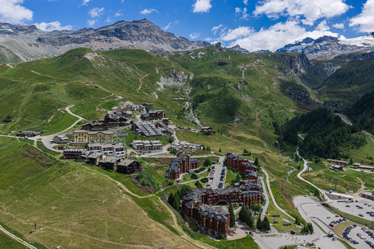 Aerial view of the alpine village of Breuil Cervinia nestled in green mountain slopes featuring traditional architecture and winding roads in Breuil Cervinia Aosta Valley Italy. Aerial view of the alpine village of Breuil Cervinia nestled in green mountain slopes featuring traditional architecture and winding roads in Breuil Cervinia Aosta Valley Italy.