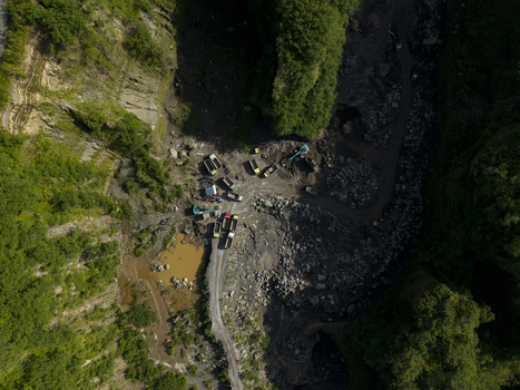 Aerial view of Tambang Pasir Merapi Kali Gendol Sand Mine with excavators and trucks operating in a rocky valley Kecamatan Cangkringan Daerah Istimewa Yogya Indonesia. Aerial view of Tambang Pasir Merapi Kali Gendol Sand Mine with excavators and trucks operating in a rocky valley Kecamatan Cangkringan Daerah Istimewa Yogya Indonesia.
