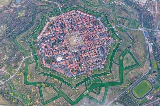 Aerial view of the star shaped fortress with its symmetrical layout and red roofed buildings nestled within lush green moats Neuf Brisach Grand Est France.