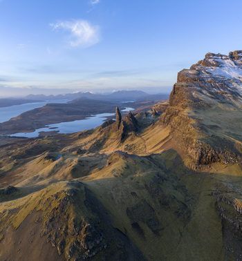Aerial view of The Storr rocky pinnacles and snow dusted cliffs overlooking the lochs under a clear blue sky Isle of Skye Scotland United Kingdom. Aerial view of The Storr rocky pinnacles and snow dusted cliffs overlooking the lochs under a clear blue sky Isle of Skye Scotland United Kingdom.