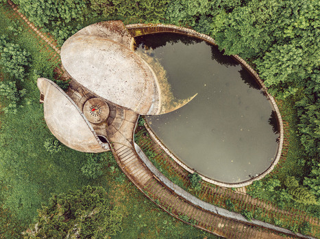 Aerial view of the Korcanica Memorial Zone featuring a concrete monument and an oval pond surrounded by lush green forest in Sanski Most Federation of Bosnia Bosnia and Herzegovina. Aerial view of the Korcanica Memorial Zone featuring a concrete monument and an oval pond surrounded by lush green forest in Sanski Most Federation of Bosnia Bosnia and Herzegovina.
