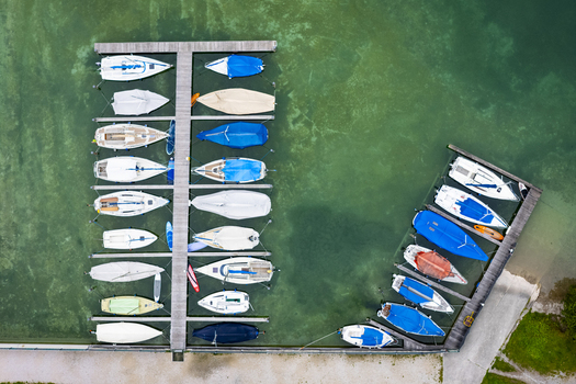 Aerial view of boats docked at Plansee s serene harbor their colorful covers contrasting with the clear turquoise water Plansee Tyrol Austria. Aerial view of boats docked at Plansee s serene harbor their colorful covers contrasting with the clear turquoise water Plansee Tyrol Austria.