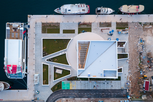 Aerial view of the new Pula AC Marina featuring modern architectural structures landscaped green areas and docked ships along the pier in Pula Croatia. Aerial view of the new Pula AC Marina featuring modern architectural structures landscaped green areas and docked ships along the pier in Pula Croatia.