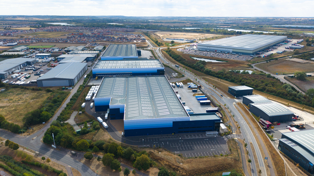 Aerial view of a large logistics hub featuring industrial warehouses and numerous HGVs parked in loading bays in Bedford England United Kingdom. Aerial view of a large logistics hub featuring industrial warehouses and numerous HGVs parked in loading bays in Bedford England United Kingdom.