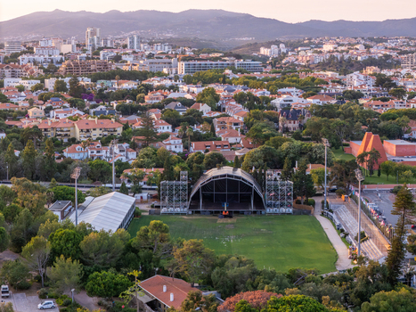 Aerial view of the outdoor stage setup at Parque Carmona surrounded by lush trees and residential buildings in Cascais Lisboa Portugal. Aerial view of the outdoor stage setup at Parque Carmona surrounded by lush trees and residential buildings in Cascais Lisboa Portugal.