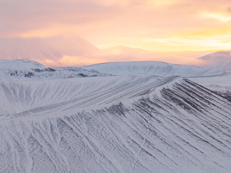 Aerial view of Hverfjall volcanic crater covered in snow under a soft golden hour sky Thingeyjarsveit Iceland. Aerial view of Hverfjall volcanic crater covered in snow under a soft golden hour sky Thingeyjarsveit Iceland.