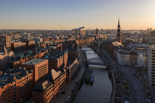 Aerial view of the historic Speicherstadt warehouse district with red brick buildings canals and the Elbphilharmonie under golden hour light in Hamburg Hamburg Germany. Aerial view of the historic Speicherstadt warehouse district with red brick buildings canals and the Elbphilharmonie under golden hour light in Hamburg Hamburg Germany.