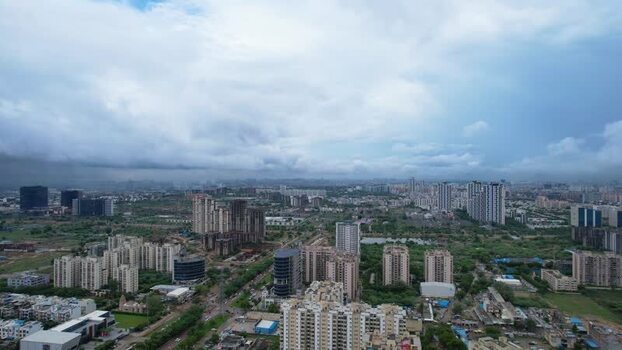 Aerial view of Gurugram skyscrapers and green fields India.