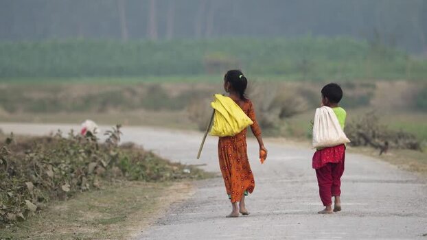 View of two young girls walking on a rural road in Bogura Bangladesh.