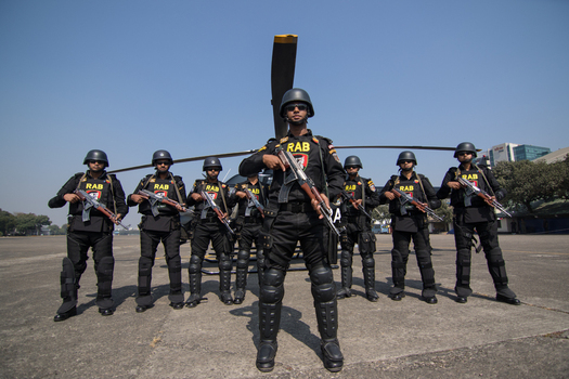 Dhaka Bangladesh 19 January 2017 View of Rapid Action Battalion officers in tactical gear holding rifles in front of a helicopter at the RAB Headquarters. Dhaka Bangladesh 19 January 2017 View of Rapid Action Battalion officers in tactical gear holding rifles in front of a helicopter at the RAB Headquarters.