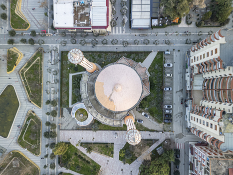 Aerial view of Fier Mosque with its prominent dome and minarets surrounded by a paved plaza green spaces and nearby urban buildings in the city center Fier Fier County Albania.