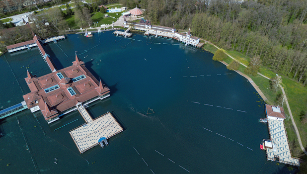Aerial view of the H&eacute;v&iacute;z Lake where the dark blue waters meet the warm hues of the bathhouse roofs and the surrounding lush greenery H&eacute;v&iacute;z Zala Hungary.
