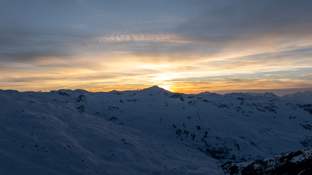 Aerial view of the snow capped peaks catching the golden light of the setting sun casting long shadows across the landscape Val Thorens Auvergne Rh&ocirc;ne Alpes France.