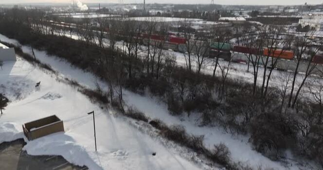 Aerial view of a freight train moving through a snowy landscape in United States. Aerial view of a freight train moving through a snowy landscape in United States.