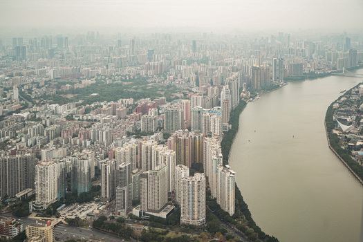 Aerial view of the dense urban skyline of Guangzhou along the Pearl River with high rise residential and commercial towers in Guangzhou Guangdong Province China. Aerial view of the dense urban skyline of Guangzhou along the Pearl River with high rise residential and commercial towers in Guangzhou Guangdong Province China.