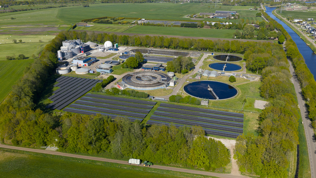 Aerial view of RWZI Echten wastewater treatment plant featuring circular tanks and solar panels surrounded by green fields in Hoogeveen Drenthe Netherlands. Aerial view of RWZI Echten wastewater treatment plant featuring circular tanks and solar panels surrounded by green fields in Hoogeveen Drenthe Netherlands.