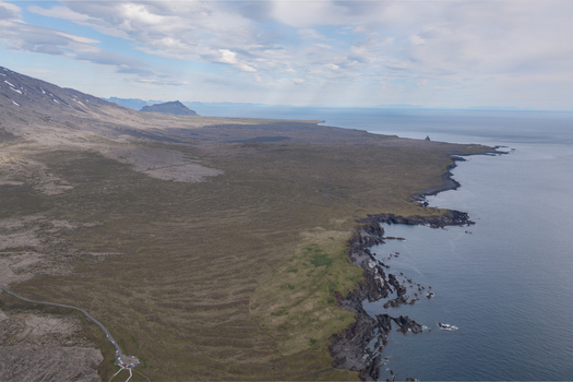 Aerial view of the rugged volcanic coastline and black sand beach at Djupalonssandur with dramatic cliffs mossy lava fields and the Atlantic Ocean in Iceland. Aerial view of the rugged volcanic coastline and black sand beach at Djupalonssandur with dramatic cliffs mossy lava fields and the Atlantic Ocean in Iceland.