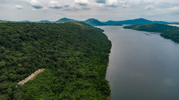 Aerial view of Akosombo Port nestled along lush green hills bordering Volta Lake featuring dense forest vegetation and calm water in Akosombo Eastern Region Ghana. Aerial view of Akosombo Port nestled along lush green hills bordering Volta Lake featuring dense forest vegetation and calm water in Akosombo Eastern Region Ghana.