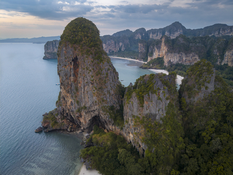 Aerial view of striking limestone cliffs and lush vegetation meet turquoise waters under a serene sky at Railay Beach Krabi Thailand. Aerial view of striking limestone cliffs and lush vegetation meet turquoise waters under a serene sky at Railay Beach Krabi Thailand.