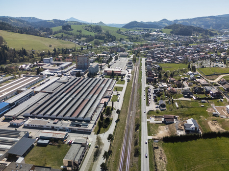 Aerial view of an industrial complex with large warehouses a straight road and a railway line passing through the town of Nizna Zilina Region Slovakia. Aerial view of an industrial complex with large warehouses a straight road and a railway line passing through the town of Nizna Zilina Region Slovakia.