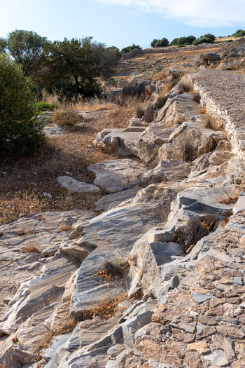 View of the ancient stone ruins and rocky landscape of the Archaeological Site of Thorikos under a clear blue sky in Thoricus Greece.