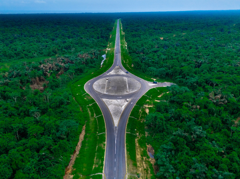 Aerial view of a modern roundabout on a road cutting through the dense tropical forest of Bonny Island in Bonny Town Rivers Nigeria. Aerial view of a modern roundabout on a road cutting through the dense tropical forest of Bonny Island in Bonny Town Rivers Nigeria.