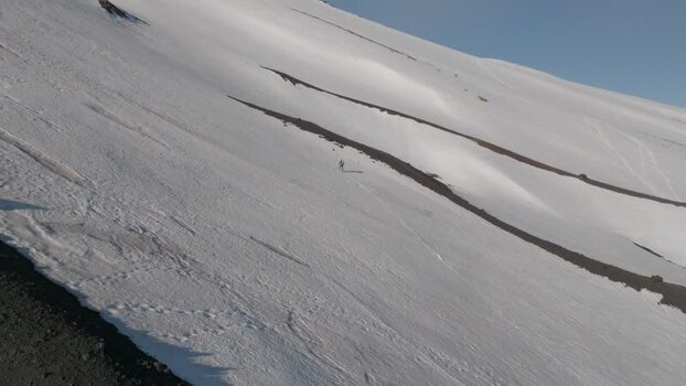 Aerial view of a person walking on the snowy slopes of Mount Etna Italy. Aerial view of a person walking on the snowy slopes of Mount Etna Italy.