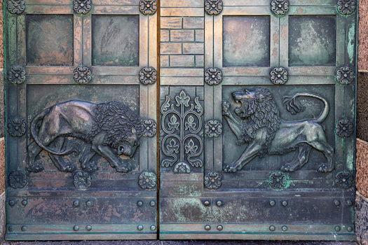 View of the ornate bronze doors of Ribe Cathedral featuring detailed lion reliefs and floral patterns in Ribe Denmark. View of the ornate bronze doors of Ribe Cathedral featuring detailed lion reliefs and floral patterns in Ribe Denmark.