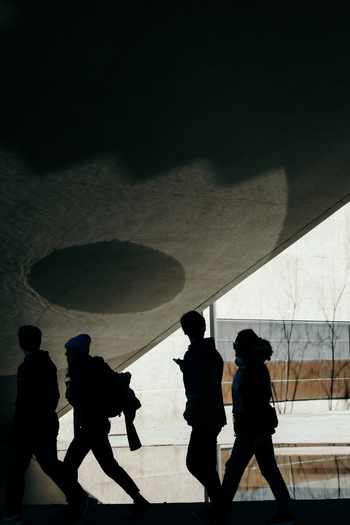 Zurich Switzerland 02 April 2023 View of silhouettes walking beneath the National Museum Zurich s arching concrete a play of light and shadow creating a dramatic urban scene. Zurich Switzerland 02 April 2023 View of silhouettes walking beneath the National Museum Zurich s arching concrete a play of light and shadow creating a dramatic urban scene.
