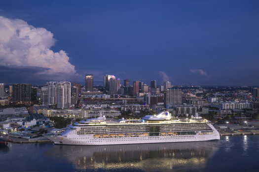 Tampa United States 04 July 2026 Aerial view of Tampa Cruise Terminal 6 with a large cruise ship docked at the pier set against the city skyline under a twilight sky.