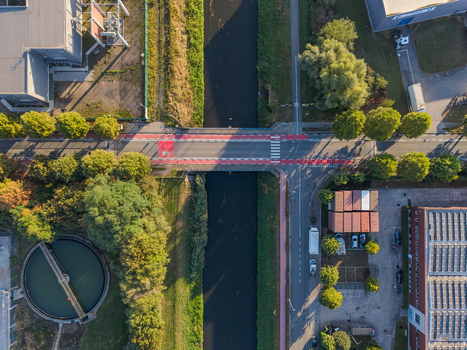 Aerial view of a bridge crossing a waterway in an industrial area with cycling lanes and urban infrastructure in Vilvoorde Flanders Belgium.