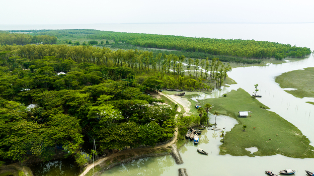Aerial view of Patharghata featuring lush green trees winding waterways and small wooden boats moored along the banks in Patharghata Barisal Division Bangladesh. Aerial view of Patharghata featuring lush green trees winding waterways and small wooden boats moored along the banks in Patharghata Barisal Division Bangladesh.