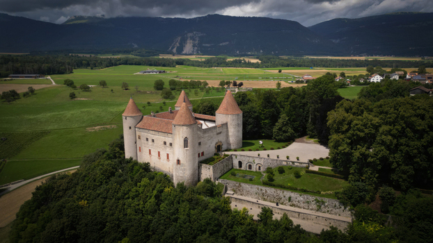 Aerial view of the ancient Château de Champvent its stone walls contrasting with the lush green trees and distant mountains Champvent Vaud Switzerland. Aerial view of the ancient Château de Champvent its stone walls contrasting with the lush green trees and distant mountains Champvent Vaud Switzerland.