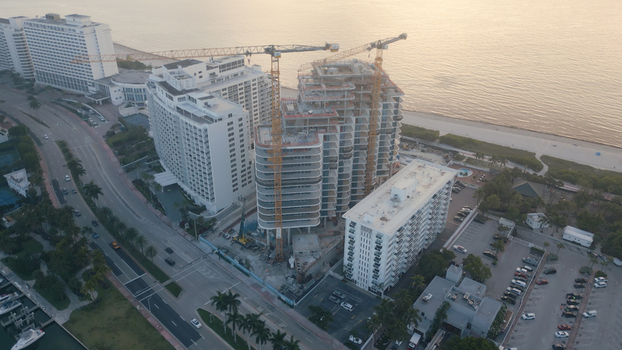 Aerial view of a high rise construction site with yellow cranes in Miami Beach Florida United States. Aerial view of a high rise construction site with yellow cranes in Miami Beach Florida United States.