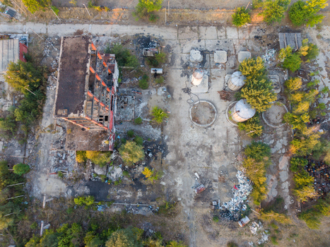 Aerial view of an abandoned industrial site featuring a ruined building concrete silos and scattered debris surrounded by trees in Velingrad Pazardzhik Bulgaria. Aerial view of an abandoned industrial site featuring a ruined building concrete silos and scattered debris surrounded by trees in Velingrad Pazardzhik Bulgaria.